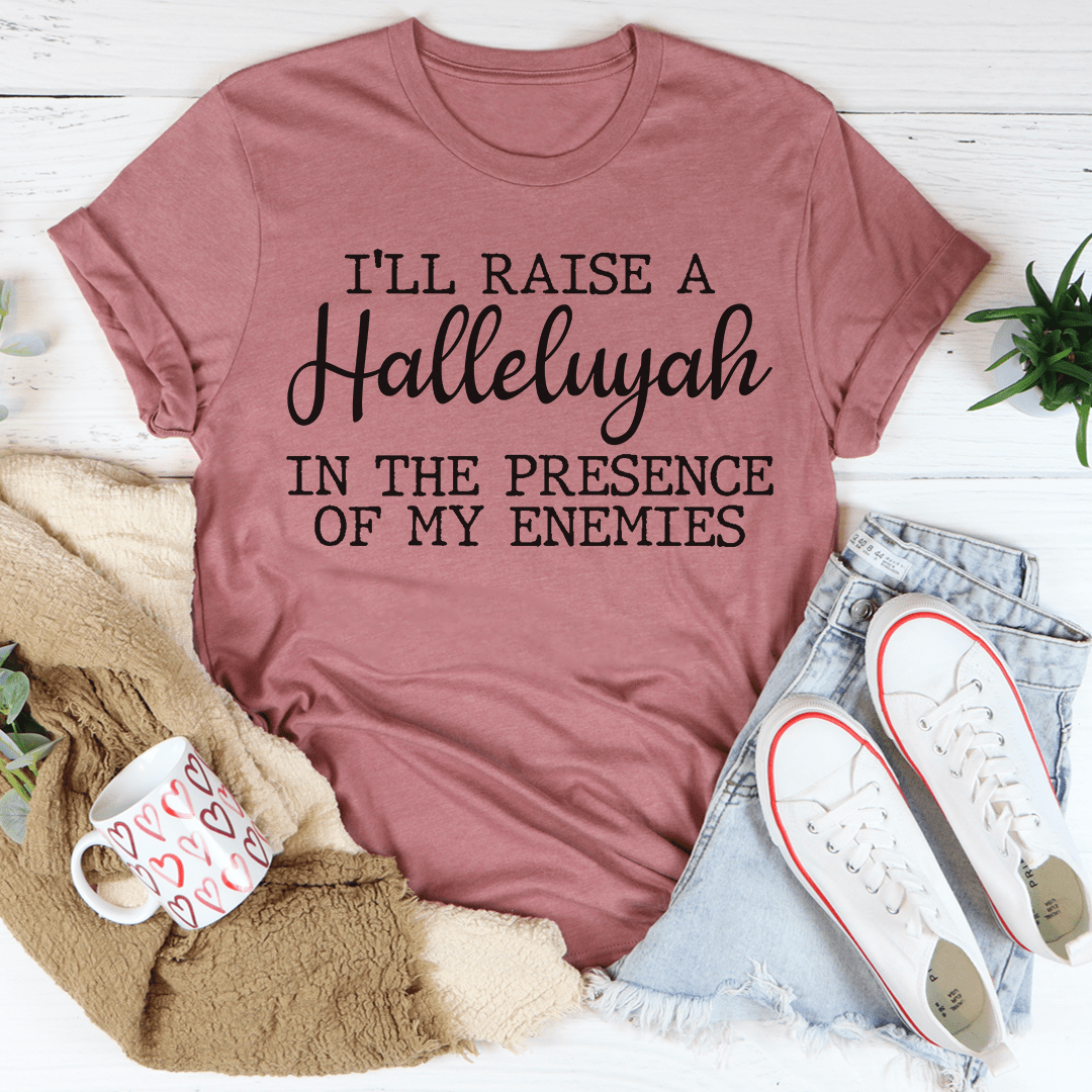 A black t-shirt featuring the phrase 'I'll Raise A Halleluyah In The Presence Of My Enemies' printed in white, showcasing a stylish and comfortable design.